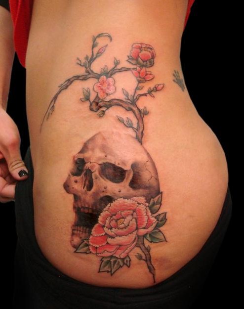 Rose and skull tattoo on hip